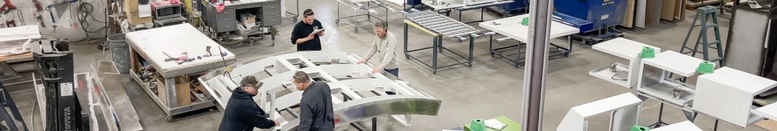 Sterling team assembling a curved canopy frame on the shop floor
