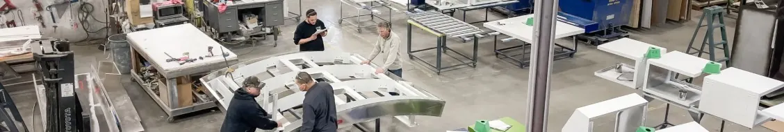 Sterling team assembling a curved canopy frame on the shop floor